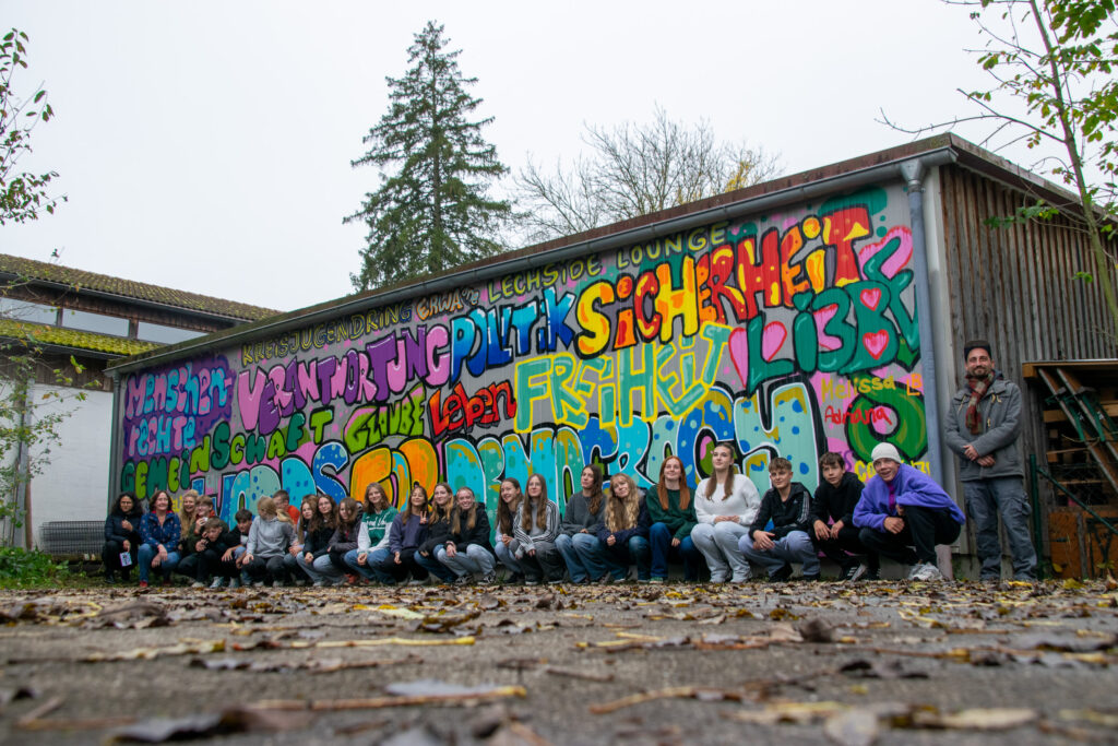 Stolz knien die Schülerinnen und Schüler der 9b vor ihrem Kunstwerk